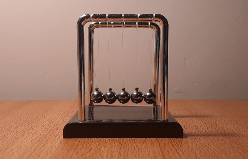 Understanding Newton Cradle and how it explains momentum conservation